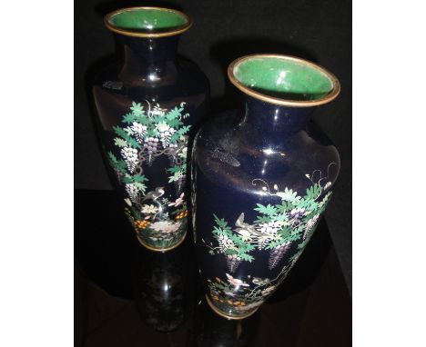 A pair of Japanese Meiji Period black ground elongated urn shaped vases decorated with birds amongst foliage and flowers, eac