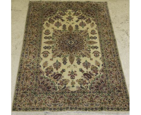 A Persian carpet, the central panel set with a stylised floral decorated starburst medallion on a cream ground with hook and 