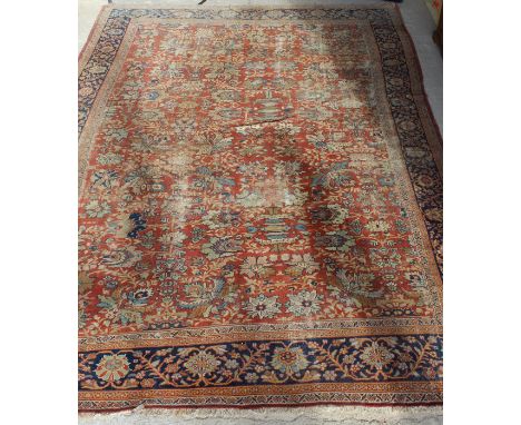 A Ziegler carpet, the central panel set with all over floral decoration on a terracotta ground, within a stepped blue, orange