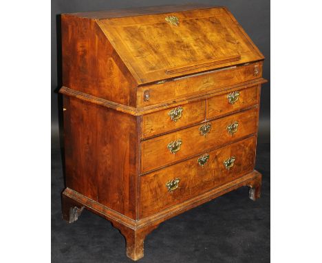 An 18th Century walnut bureau, the cross-banded top above a sloping fall with feather-banding, opening to reveal a stepped fi