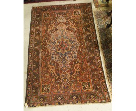 A Persian style carpet, the central panel set with a stylised starburst medallion on a red and blue ground with stylised flor