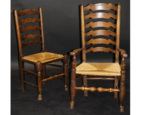 A set of twelve assorted 19th Century oak ladder back dining chairs including four carvers with rush seats, raised on turned 