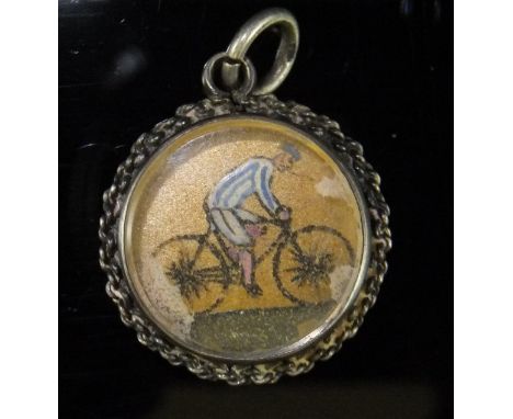 An Essex Crystal compass, the reverse painted with a cyclist in blue and white top, housed within silver mounts (by Edward Du