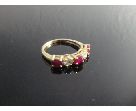 An 18 carat gold ruby and diamond set dress ring, the three rubies interspaced with micro-chip diamonds arranged as flower he