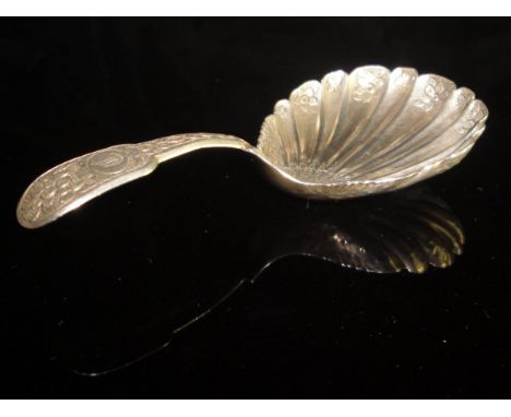 A George IV silver caddy spoon with shell-shaped bowl and embossed foliate and shell decoration initialled "C" to the cartouc