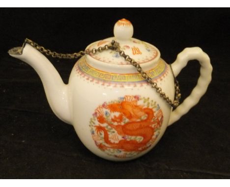 A Chinese miniature teapot with five toed dragon and phoenix medallion decoration, the white metal spout cover with flower he