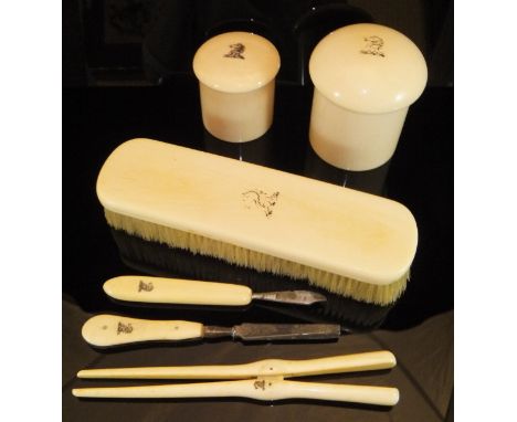 A collection of various carved and turned ivory wares, including two dressing table pots, a pair of glove stretchers, two man