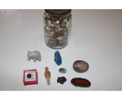 A glass jar and contents of various polished stones and pebbles; a box containing a small carved wooden Netsuke; carved stone