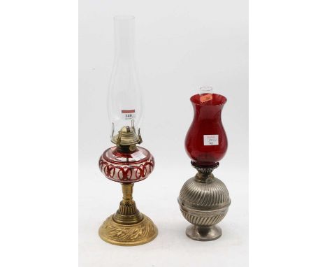 A late Victorian oil lamp, having a ruby tinted glass font, on a pierced brass foot; together with one other oil lamp, having