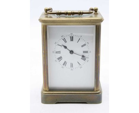 A 20th century lacquered brass cased carriage clock having an enamel dial with inner Roman numerals and outer Arabic numerals