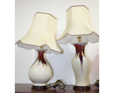 A contemporary table lamp, on a red and white drip-glazed ground, with silk shade; together with one other similar example (2