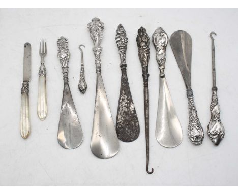 A collection of Victorian and later silver handled shoe-horns; together with silver handled button hooks, and a silver bladed