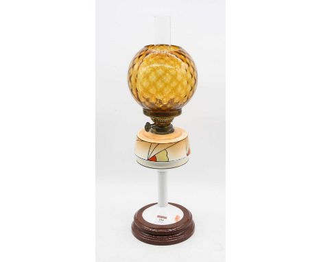 A 1930s oil lamp, having an orange tinted globular shade over an Art Deco design font, on a plain column and socle base, h.53