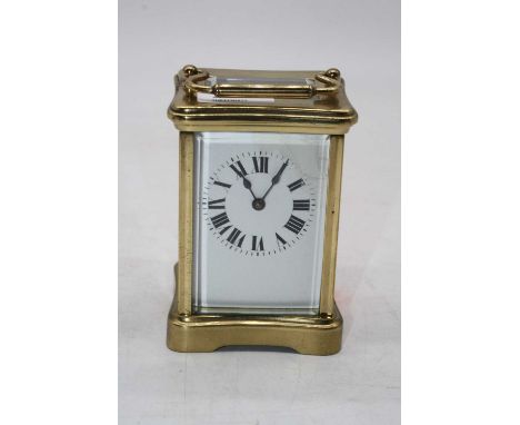 A 20th century lacquered brass carriage clock, having an enamelled dial with Roman numerals, visible platform lever escapemen