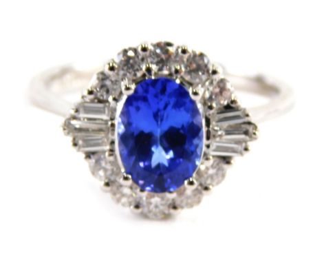 An 18ct white gold tanzanite and diamond dress ring, the oval cut tanzanite, approx. 1.12cts, surrounded by a halo of ten rou