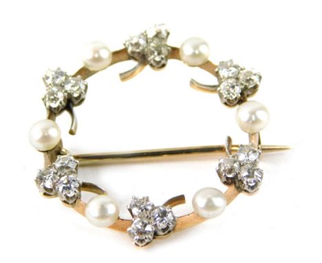 A seed pearl and diamond circular brooch,  set with three leaf clovers, each with tiny diamonds in claw setting, with culture