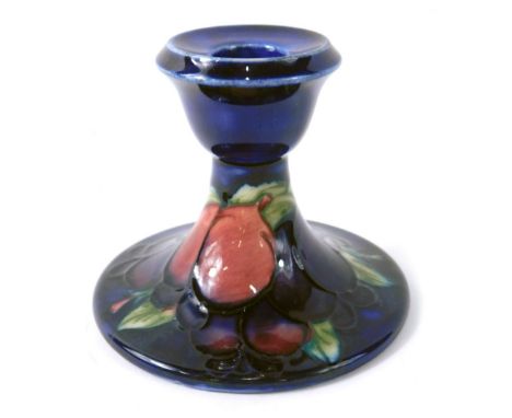 A Moorcroft pottery Wisteria pattern squat candlestick, on blue ground, impressed marks beneath, 9cm high.  
