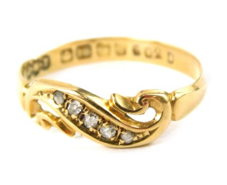 An Edwardian 18ct gold diamond twist ring, set with five tiny diamonds, in scroll design setting, ring size O½, 1.7g all in.