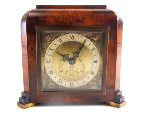 An Elliott London walnut cased mantel clock, with 9cm wide Roman numeric dial, with spandrels, in a shaped case, with hand wi