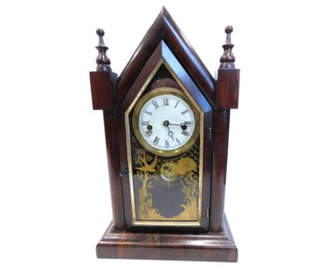 A late 19thC American mantel clock, in a rosewood case, the arched case with turned finials, above a later printed paper dial