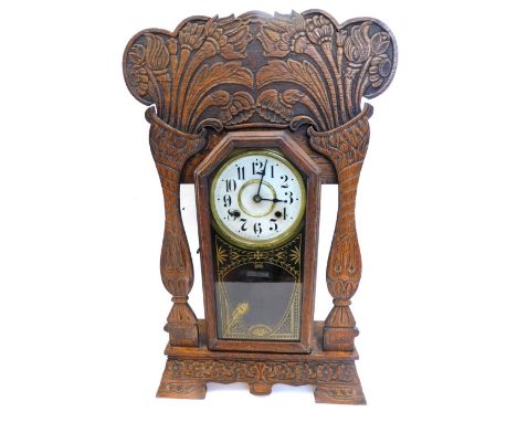 A late 19thC American mantel clock, in carved walnut gingerbread style case, stamp to dial Made By The New Haven Clock Compan