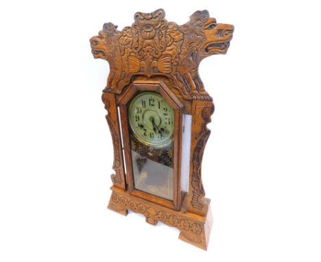 A 19thC gingerbread clock, with 13cm diameter, Arabic dial, marked Newhaven Clock Co, USA in heavily carved cased, with pendu