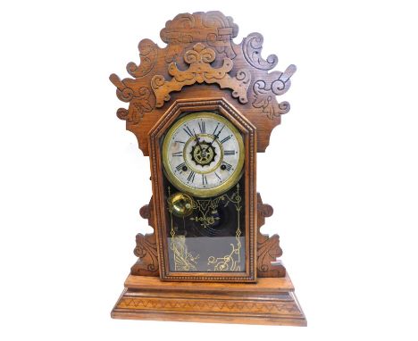 A late 19thC American mantel clock, in walnut gingerbread style case, the dial stamped Waterbury Clock Company USA, and with 