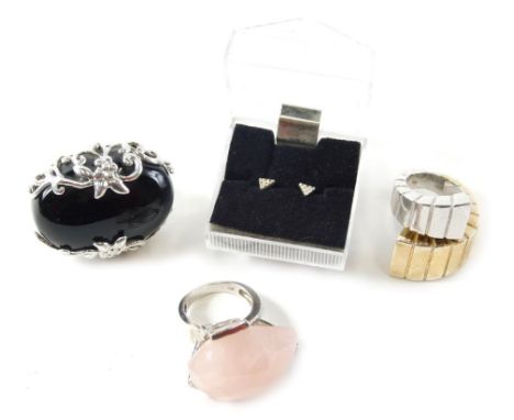 Three dress rings, comprising a silver and black onyx four scroll dress ring, a silver and rose quartz dress ring, a bi colou