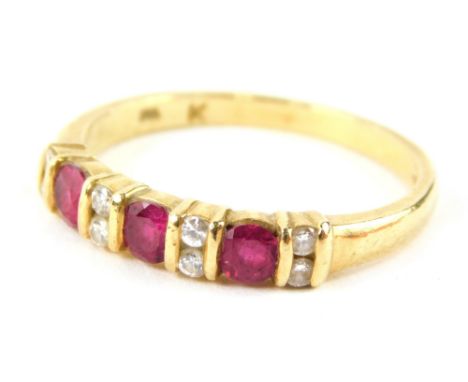 An 18ct gold ruby and diamond half hoop dress ring, set with three round brilliant cut rubies, in tension setting with eight 