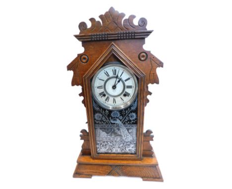 A late 19thC American mantel clock, in a walnut gingerbread style case, the painted dial stamped Manufactured By The Ansonia 