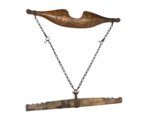A late 19thC wooden yoke, with iron chain, 87cm long, and another.