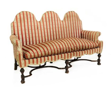 A Queen Anne style sofa,upholstered in a red and floral striped fabric, on Spanish-style feet united by an x-frame stretcher,