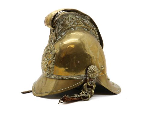 A Merryweather pattern brass fireman's helmet,late 19th to early 20th century, the comb embossed with dragons, mounted to the