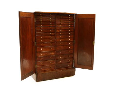 A Victorian collectors cabinet19th Century, with arching panelled doors opening to reveal 32 graduated drawers each with turn