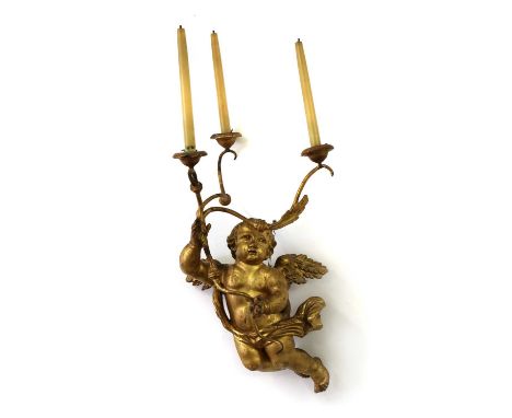 A giltwood putto wall light,19th century, Italian, the winged figure supporting a three-branch pricket candelabrum set with t