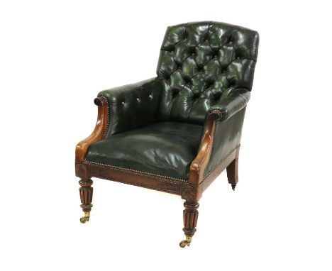 A George IV walnut library chair, with green button leather upholstery and down-swept arms over a pair of reeded and turned f