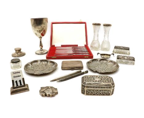 A collection of silver items,to include a pair of Indian dishes, with embossed decoration depicting a figure amongst animals 