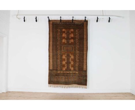 A Hatchli Bokhara rug,of typical design, with four architectural quadrants to a cinnamon ground and darker borders,221 x 127c