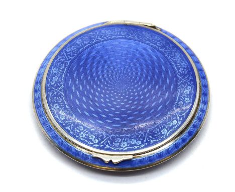 An enamelled silver compact,1930s, likely Austrian, of disc form, with blue guilloche enamel over a variety of engine-turned 