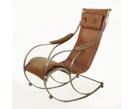 A rocking chair,after a design manufactured by R W Winfield, with a tan leather seat and a head cushion