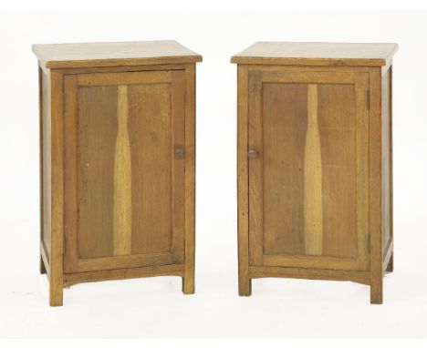 A pair of oak bedside cabinets,each with chamfered tops, over panelled doors and a single shelf,40.5cm wide 34cm deep67cm hig