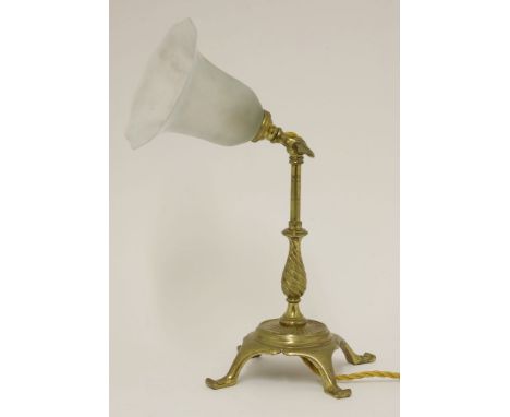 A brass table lamp,with an hinged light, the stand with spiral cast details, with a frosted clear glass and opalescent shade,