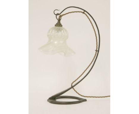 An Arts & Crafts wrought iron table lamp, fitted with an iridescent glass shade, 39.5cm high