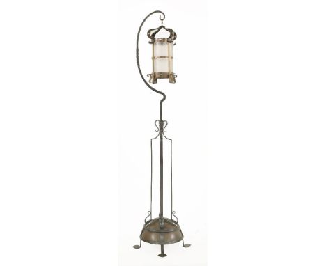 An Arts and Crafts copper and wrought iron lamp standard,the copper lantern with spiral glass shade raised on a wrought iron 