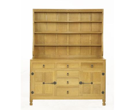 A Robert 'Mouseman' Thompson oak dresser,the panelled back with three shelves, over an adzed top, with an arrangement of six 