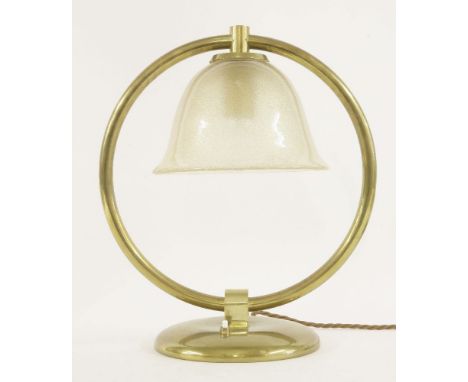 An Italian brass table lamp, by Seguso, raised on a ring, with an aventurine bell-shaped glass shade, 40cm high