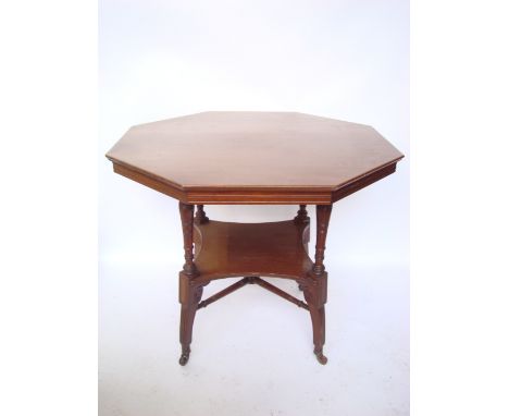 A late Victorian aesthetic movement octagonal mahogany table, on ring turned baluster supports united by an undertier and tur
