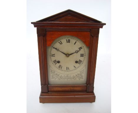 An early 20th Century mahogany cased architectural mantle clock, the silvered foliate engraved dial with Roman numerals and m