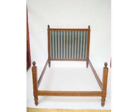 A 19th Century French walnut double bed frame, the headboard upholstered with striped blue and grey fabric, the frame fluted 