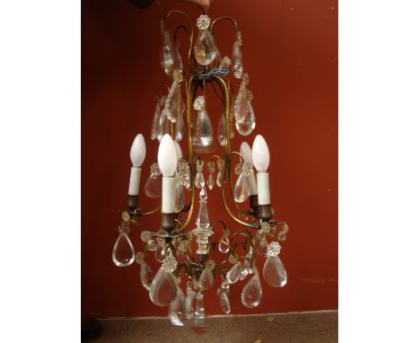 A 20th century Venetian gilt brass five light chandelier, the open scroll frame hung with cut and cabochon pear shaped glass 